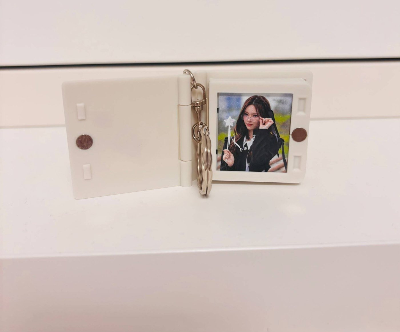 White album keychain opened with a portrait inside